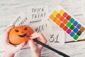 Fall Halloween crafts. Female hands draw Jack OÃ¢â¬â¢ Lanterns on o